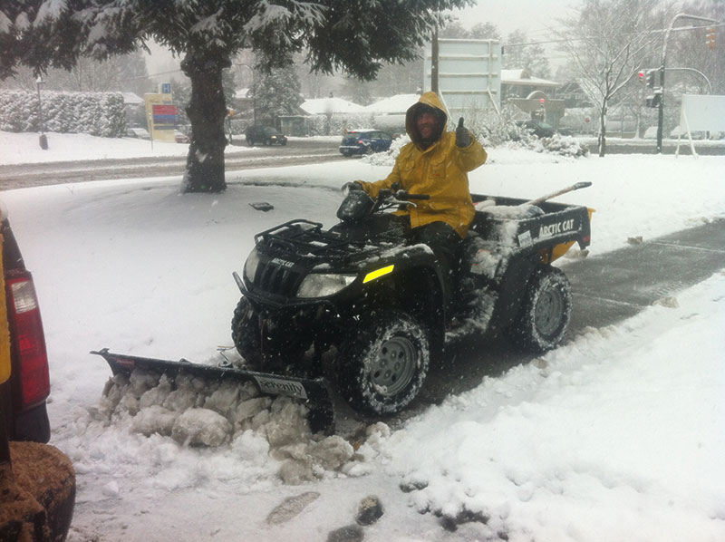 Serenity Landscapes tractor removing snow on a wintry day.